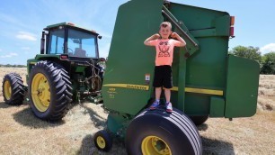 'Using tractors to bale hay | Playing on the farm with tractors for kids'